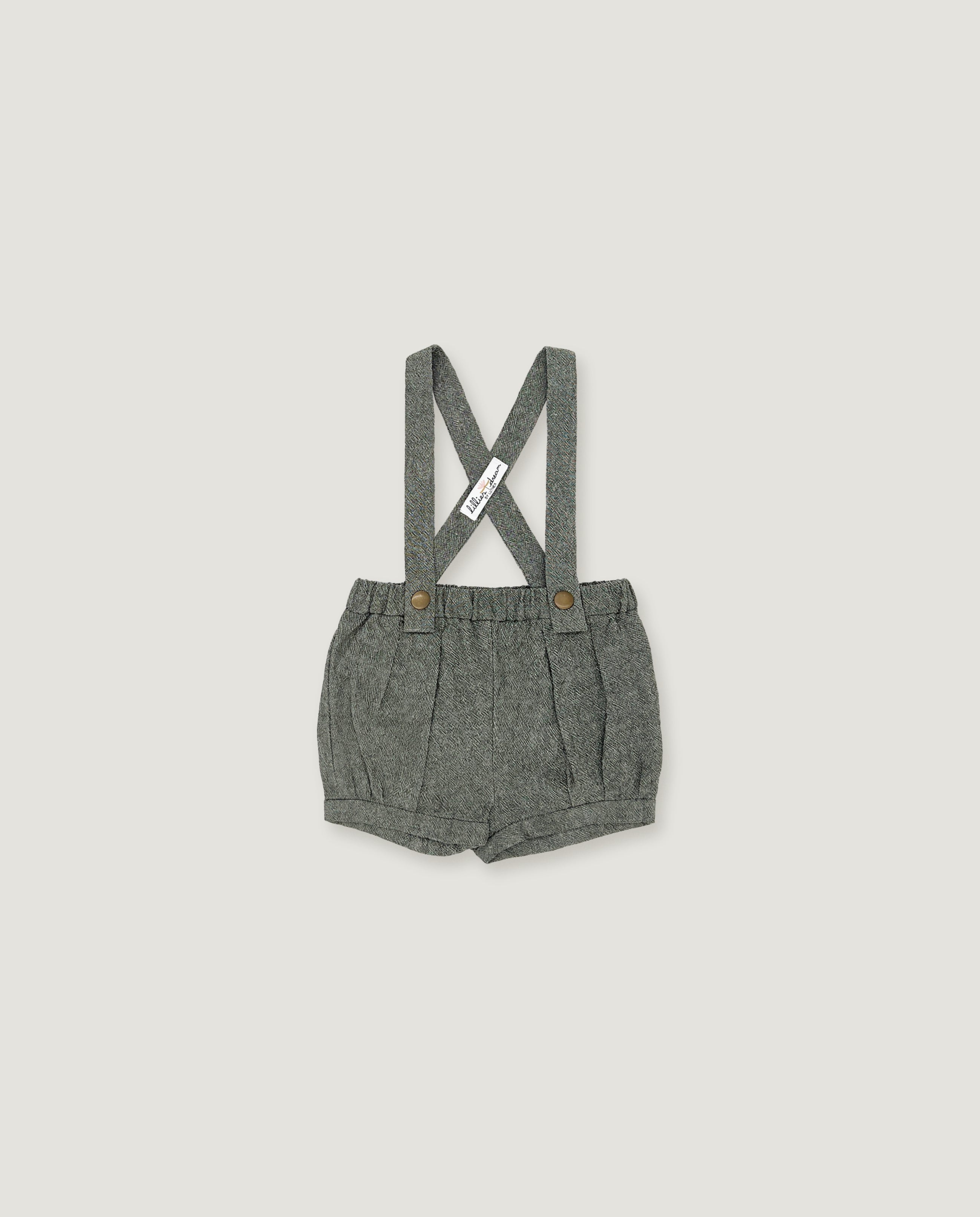 A pair of toddler's gray woven linen suspender shorts with a pleated front and adjustable shoulder straps, shown flat on a light gray background.