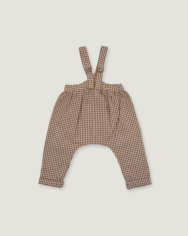 Brown and beige gingham patterned baby overalls with shoulder straps, laid flat on a light gray background.