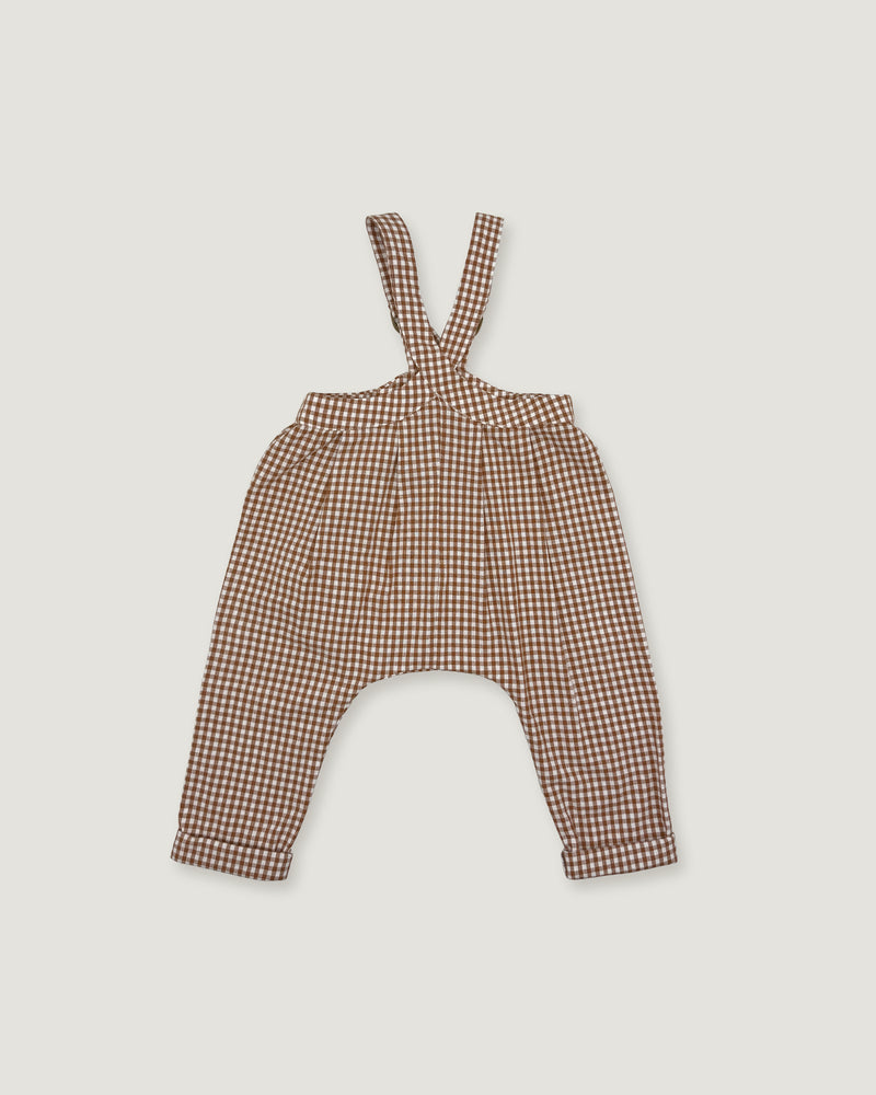 A pair of toddler's harem-style suspenders in a brown and beige gingham pattern, laid flat against a light gray background.