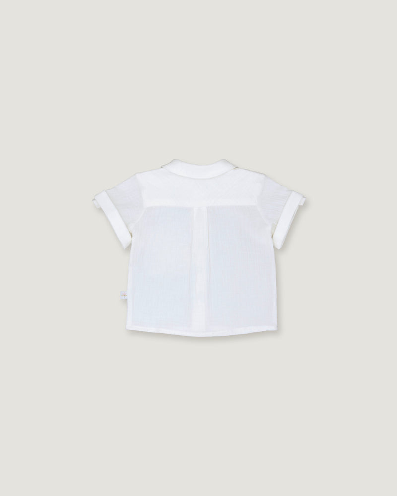 A white short-sleeve baby shirt with a V-neck and front button closure, shown from the back on a light beige background.