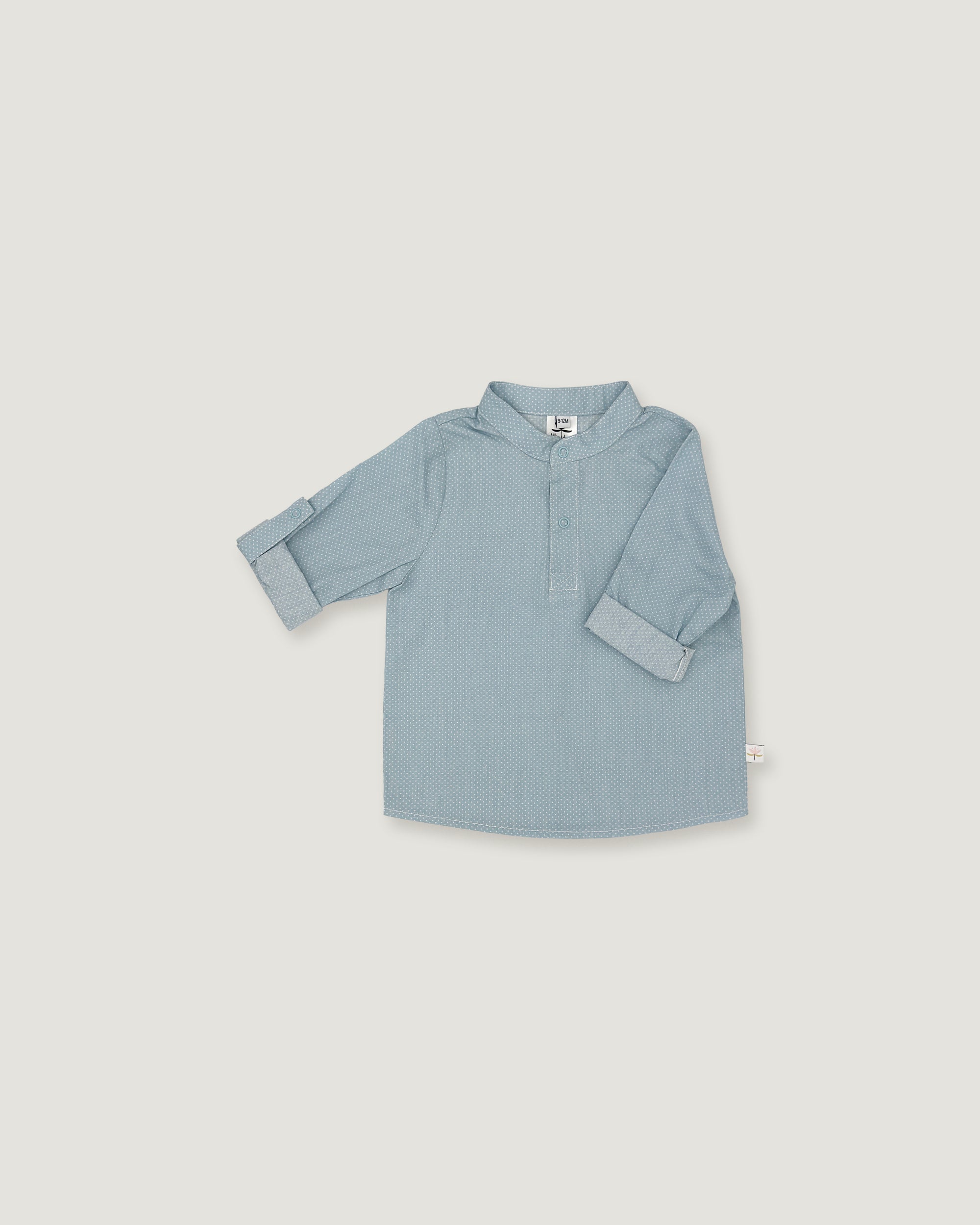 A light blue long-sleeve shirt for toddlers, featuring a polo-style collar and a short button placket, laid flat against a neutral light gray background.