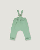 A pair of baby or toddler sage green suspenders with adjustable straps and a front pocket, laid flat on a light gray background.