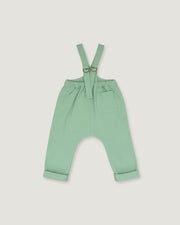 A pair of baby or toddler sage green suspenders with adjustable straps and a front pocket, laid flat on a light gray background.
