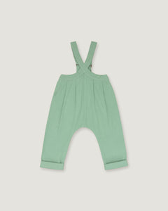A mint green baby romper with adjustable shoulder straps and a wide leg design, shown flat on a light gray background.