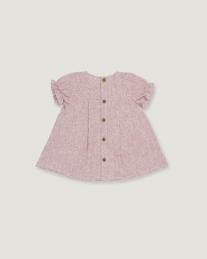 A pink and white gingham baby top with short ruffled sleeves and a button-up front, shown flat on a light gray background.