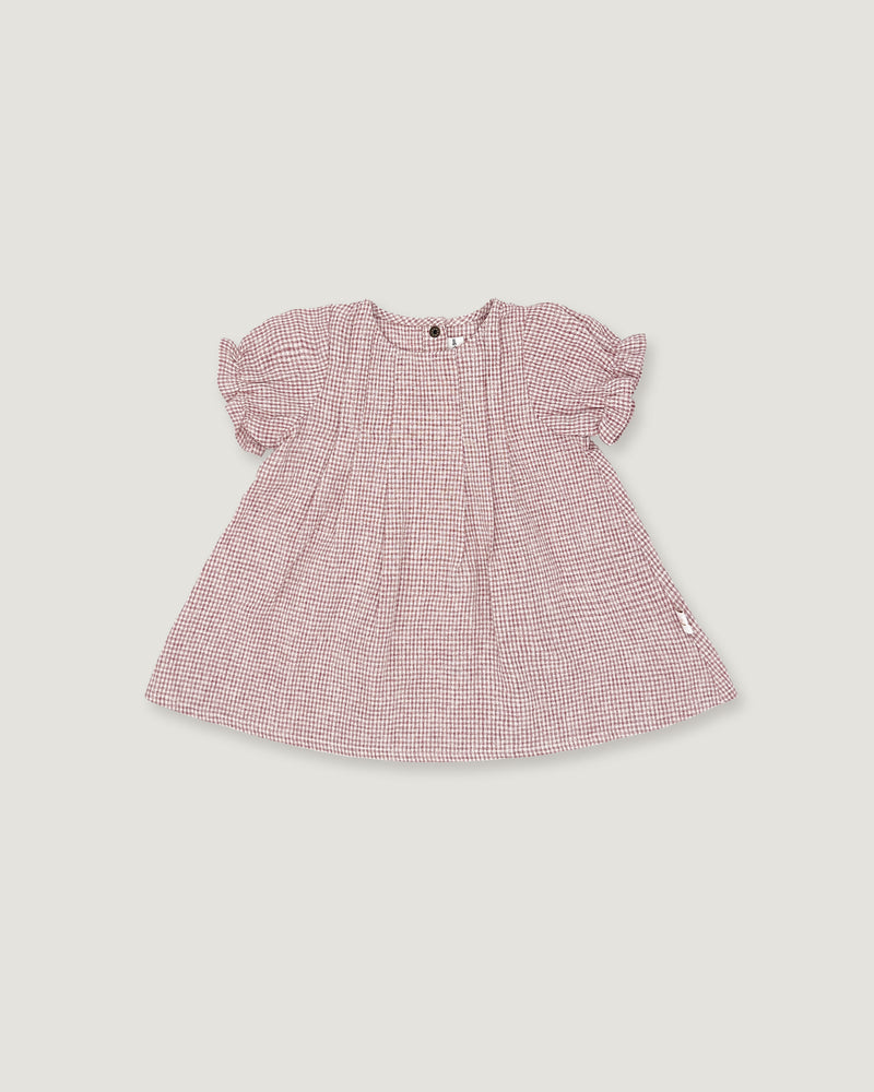 A pink and white micro-check patterned baby dress with short puff sleeves, shown flat on a light gray background.