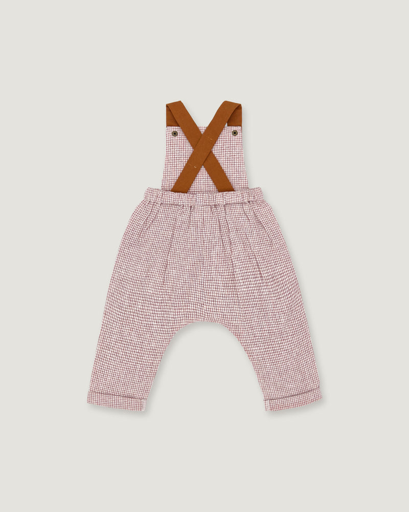 A baby romper with pink and white micro-check patterned pants, brown suspenders, and an elastic waistband, shown flat on a light gray background.