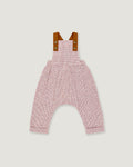 A baby romper with a pink and white micro-check pattern, featuring brown leather-like shoulder straps with snap buttons, shown flat on a light gray background.