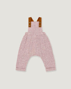 A baby romper with a pink and white micro-check pattern, featuring brown leather-like shoulder straps with snap buttons, shown flat on a light gray background.