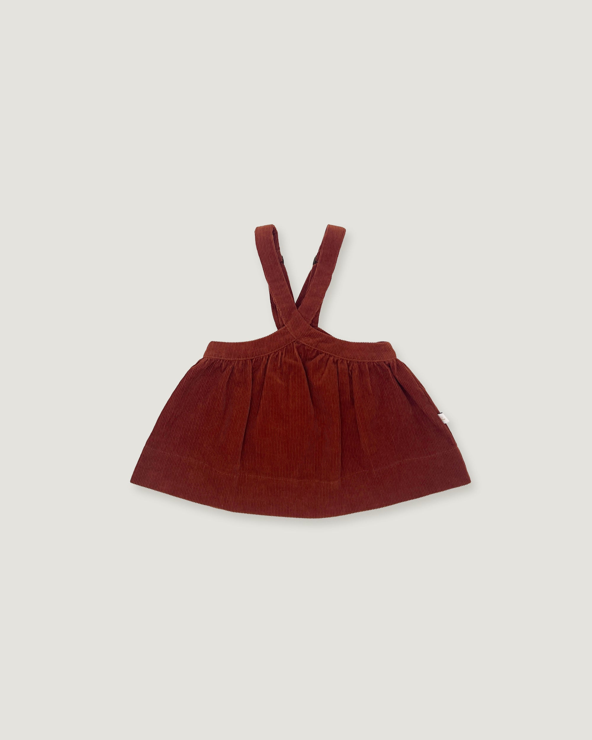 A dark reddish-brown corduroy baby dress with shoulder straps, laid flat against a light gray background.