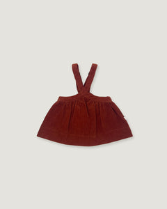 A dark reddish-brown corduroy baby dress with shoulder straps, laid flat against a light gray background.