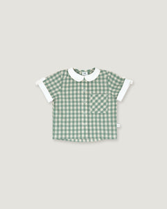 A baby short-sleeve button-up shirt in a green and white gingham pattern, featuring a white Peter Pan collar and white ruffled cuffs, laid flat on a light gray background.