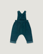 A pair of toddler corduroy overall jumpsuit in a deep teal blue-green color, featuring adjustable shoulder straps that cross over the chest and cuffed harem-style legs, shown flat on a light gray background.