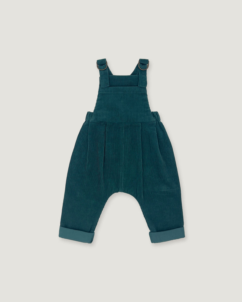 A pair of toddler corduroy overall jumpsuit in a deep teal blue-green color, featuring adjustable shoulder straps that cross over the chest and cuffed harem-style legs, shown flat on a light gray background.