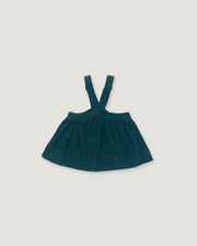 A dark teal corduroy baby dress with shoulder straps, laid flat on a light gray background.