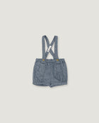A pair of toddler boy's denim shorts with adjustable shoulder straps, featuring a textured blue-gray fabric and small gold-tone snap buttons at the waistband, shown flat on a light beige background.