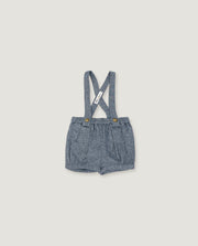 A pair of toddler boy's denim shorts with adjustable shoulder straps, featuring a textured blue-gray fabric and small gold-tone snap buttons at the waistband, shown flat on a light beige background.