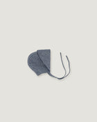 A denim blue linen bonnet with a long visor rolled up  on a white background