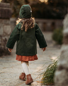 Back view of the girl in the Evergreen bonnet and matching coat, highlighting the quality and durability of sustainable children’s wear for hand-me-downs.