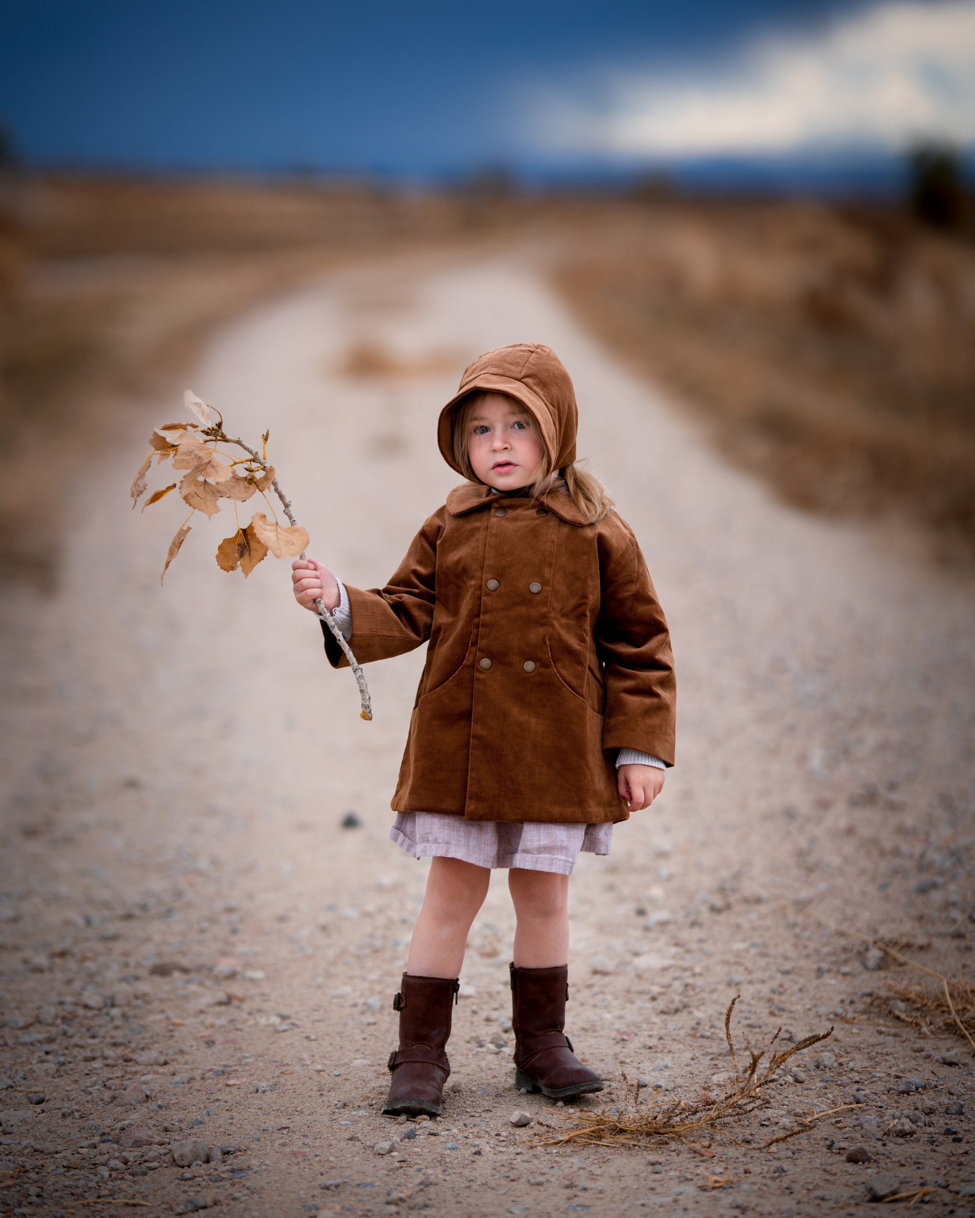 Model girl wearing the Camel Bonnet, front view - This image features the model showcasing the bonnet from the front, highlighting its snug fit and timeless style on the little one.
