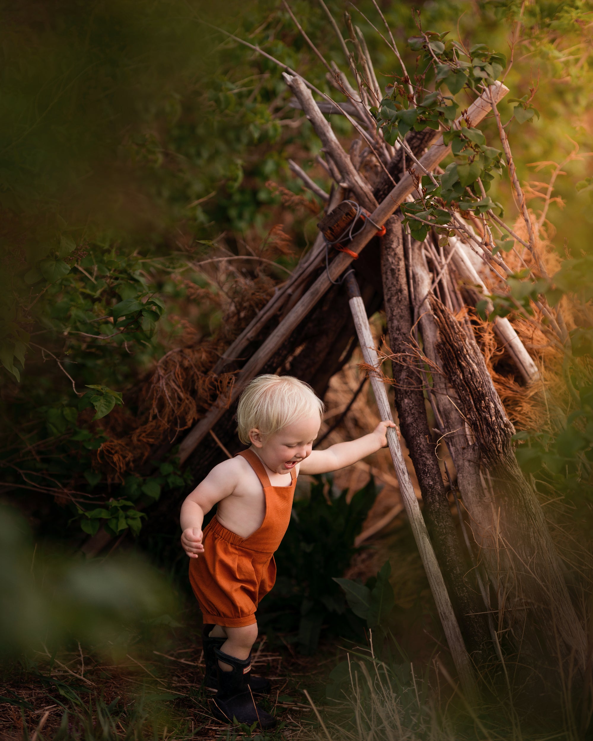 Model boy playing in Burnt Orange Short Overalls - This dynamic photo captures the boy in action, emphasizing the versatility and all-day comfort of the shortalls while he enjoys his playtime.