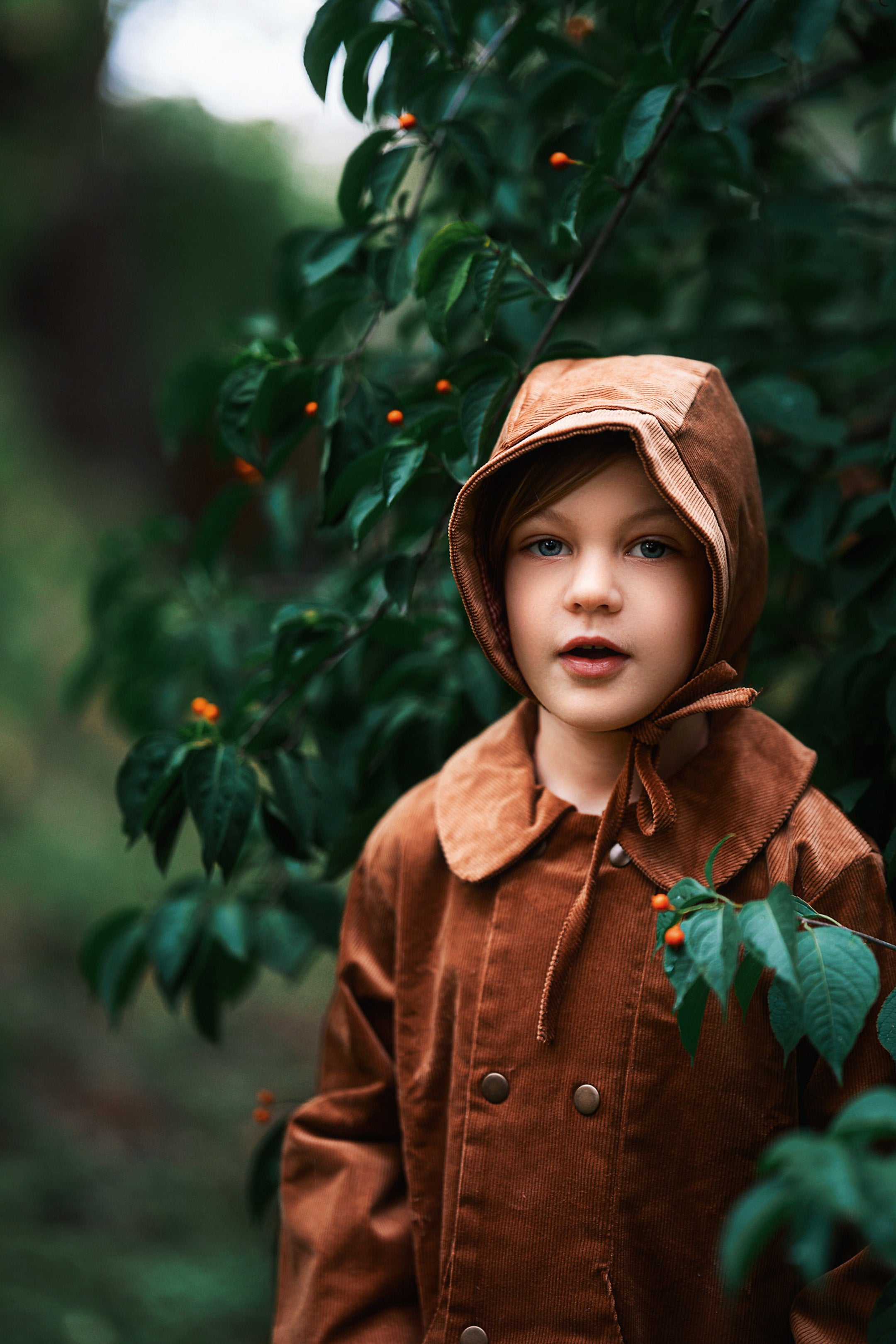 A close-up view of the Camel coat on a boy model. It  reveals the snap closures and Peter Pan collar, ensuring comfort for kids while promoting eco-friendly fashion.