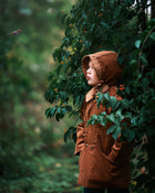 A detailed side view showcases Ezra wearing both the Camel coat and matching bonnet, highlighting the sustainable design that kids will love.