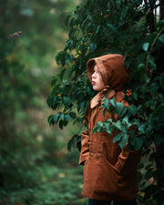 A detailed side view showcases Ezra wearing both the Camel coat and matching bonnet, highlighting the sustainable design that kids will love.
