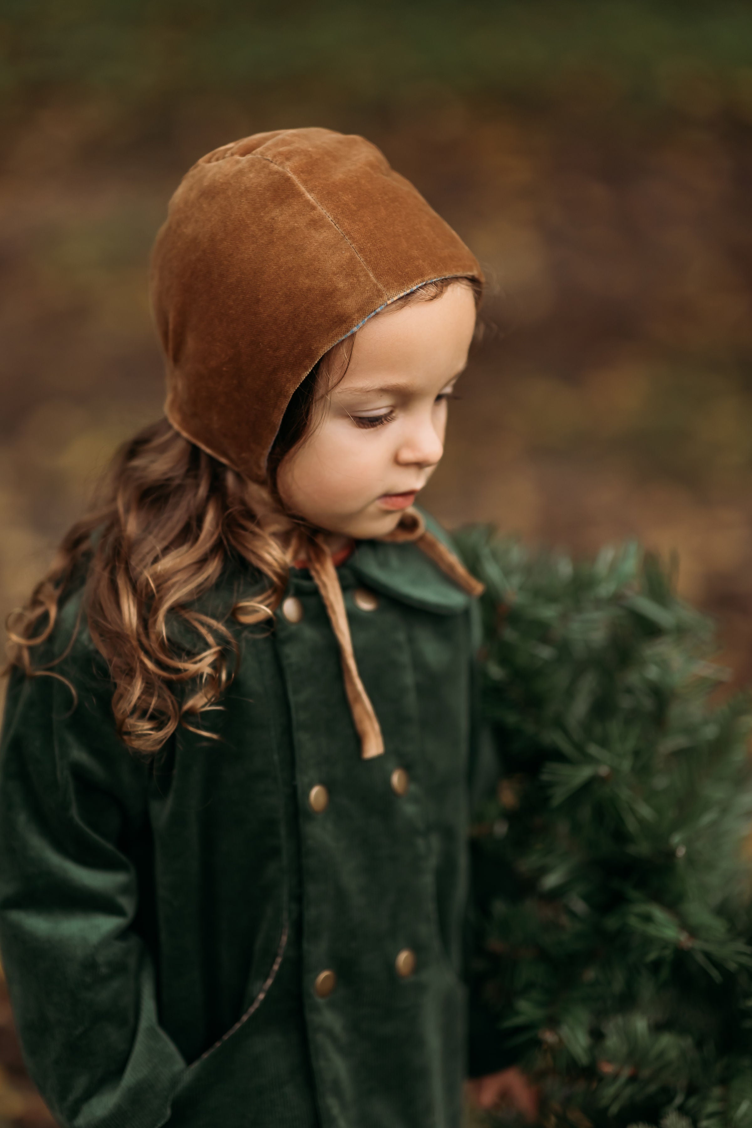Side view of the Gold Velvet Bonnet on a model, emphasizing the soft brushed gingham cotton interior that provides gentle comfort against delicate skin.