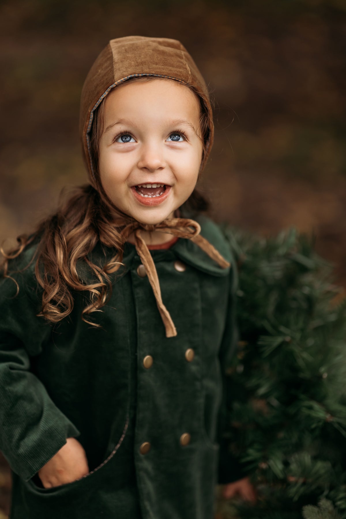 3-year-old girl happily wearing the Gold Velvet Bonnet, highlighting its sophisticated style and rich velvet fabric that enhances any outfit for formal events or everyday wear.