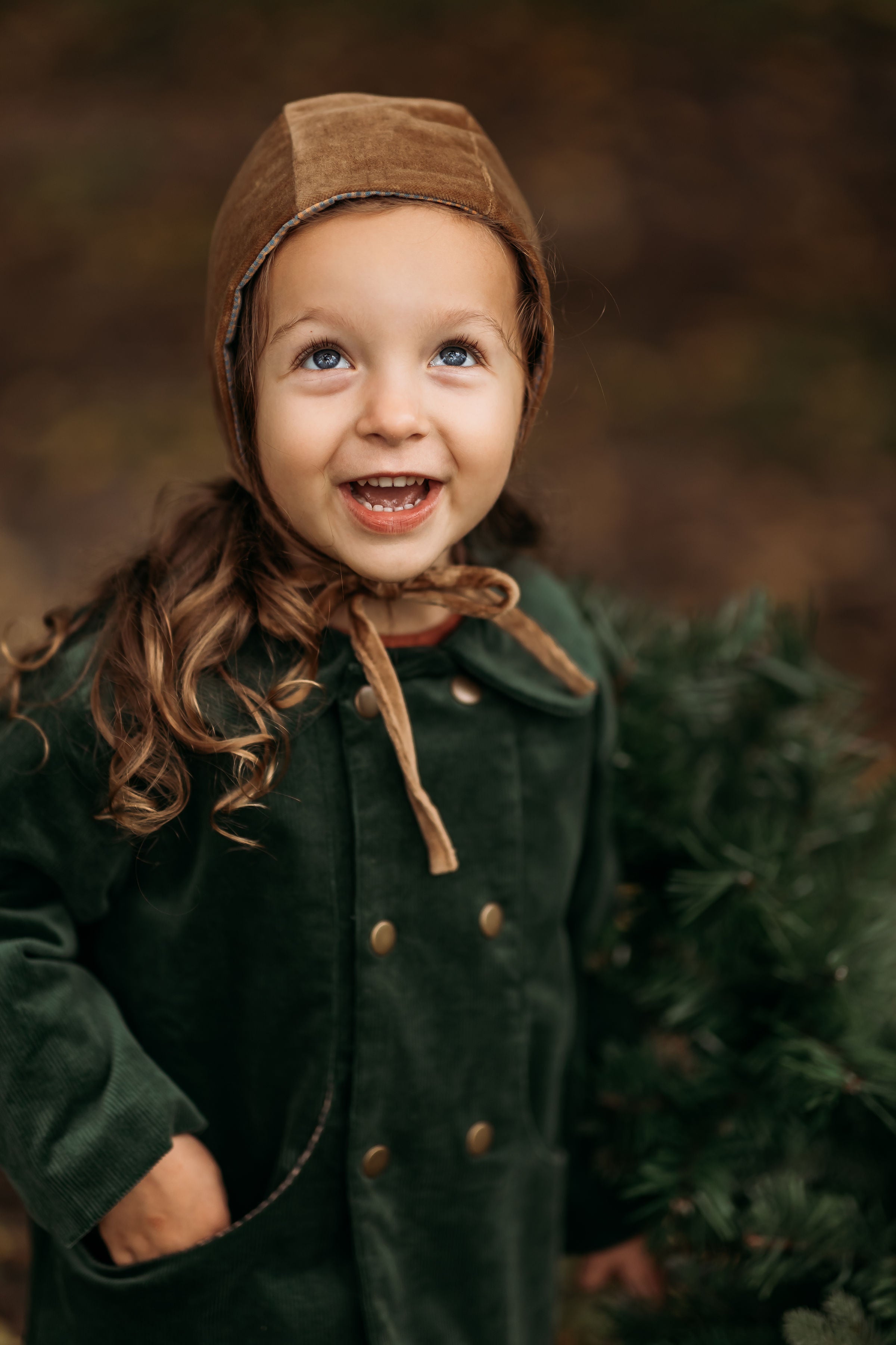 3-year-old girl happily wearing the Gold Velvet Bonnet, highlighting its sophisticated style and rich velvet fabric that enhances any outfit for formal events or everyday wear.