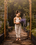 Young girl holding lavender in a garden setting