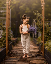 Young girl holding lavender in a garden setting